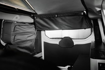 The rear pocket is nothing less but a textile wardrobe: With numerous storage compartments and an integrated blind for the rear window, this original accessory is a true multi-talent. When it is not in use, the pocket can be stretched away flat.