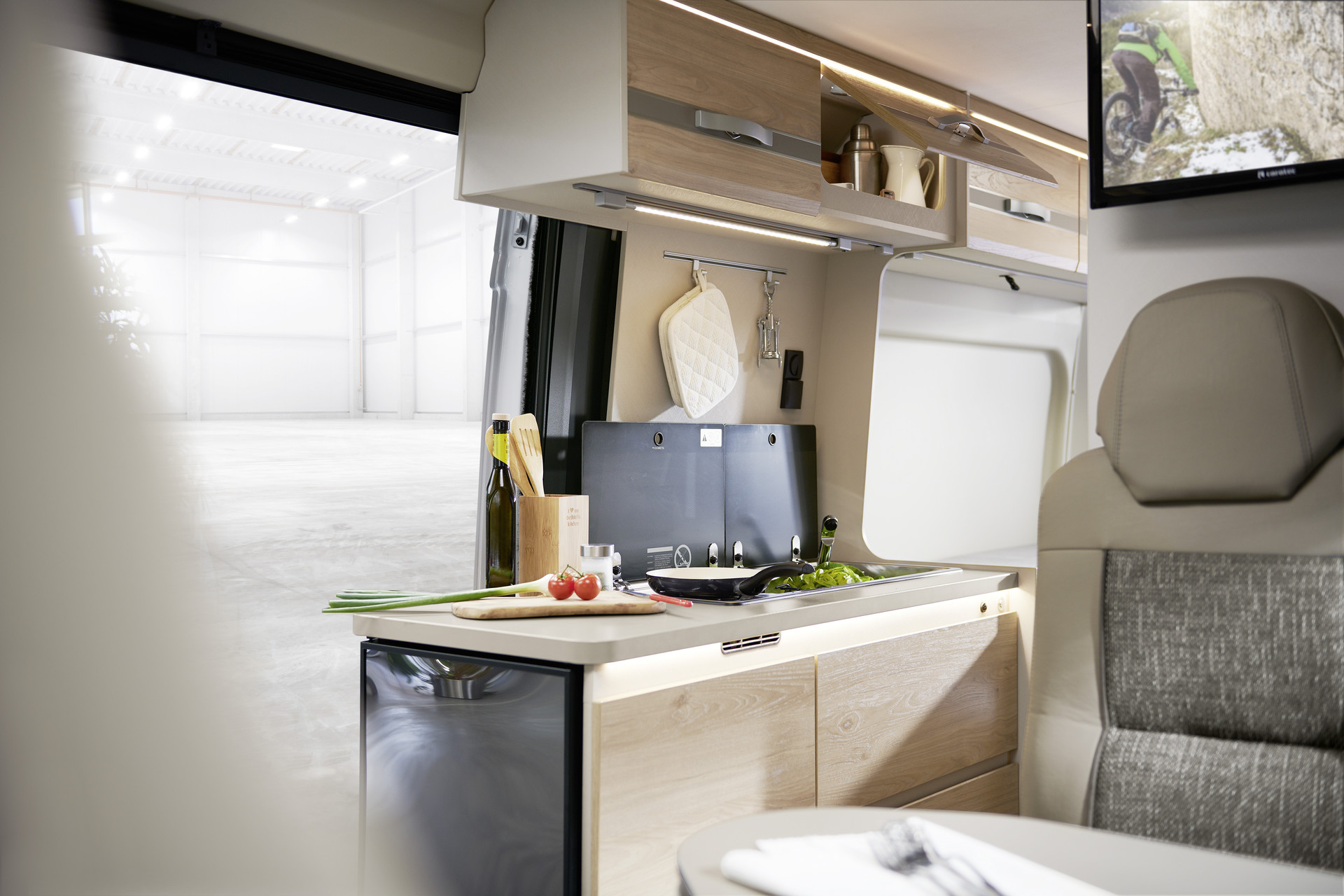 Enjoy some (mobile) home cooking. The kitchen makes optimal use of the available space. Thanks to a door that opens 180°, the large fridge is easily accessible from both outside and inside the vehicle