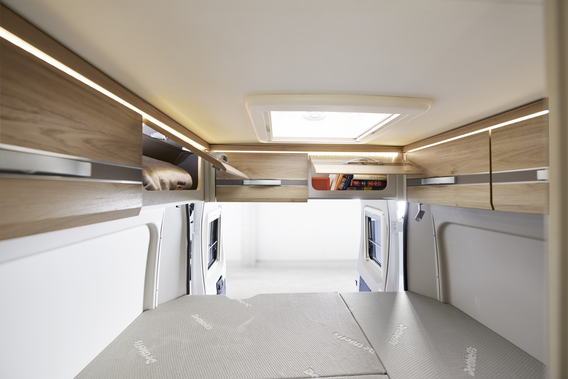 The standard overhead lockers above the rear door provide additional storage space and feature ambient lighting.
