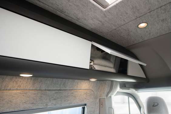 Continuous overhead lockers with integrated lights. Push-to-open flaps.