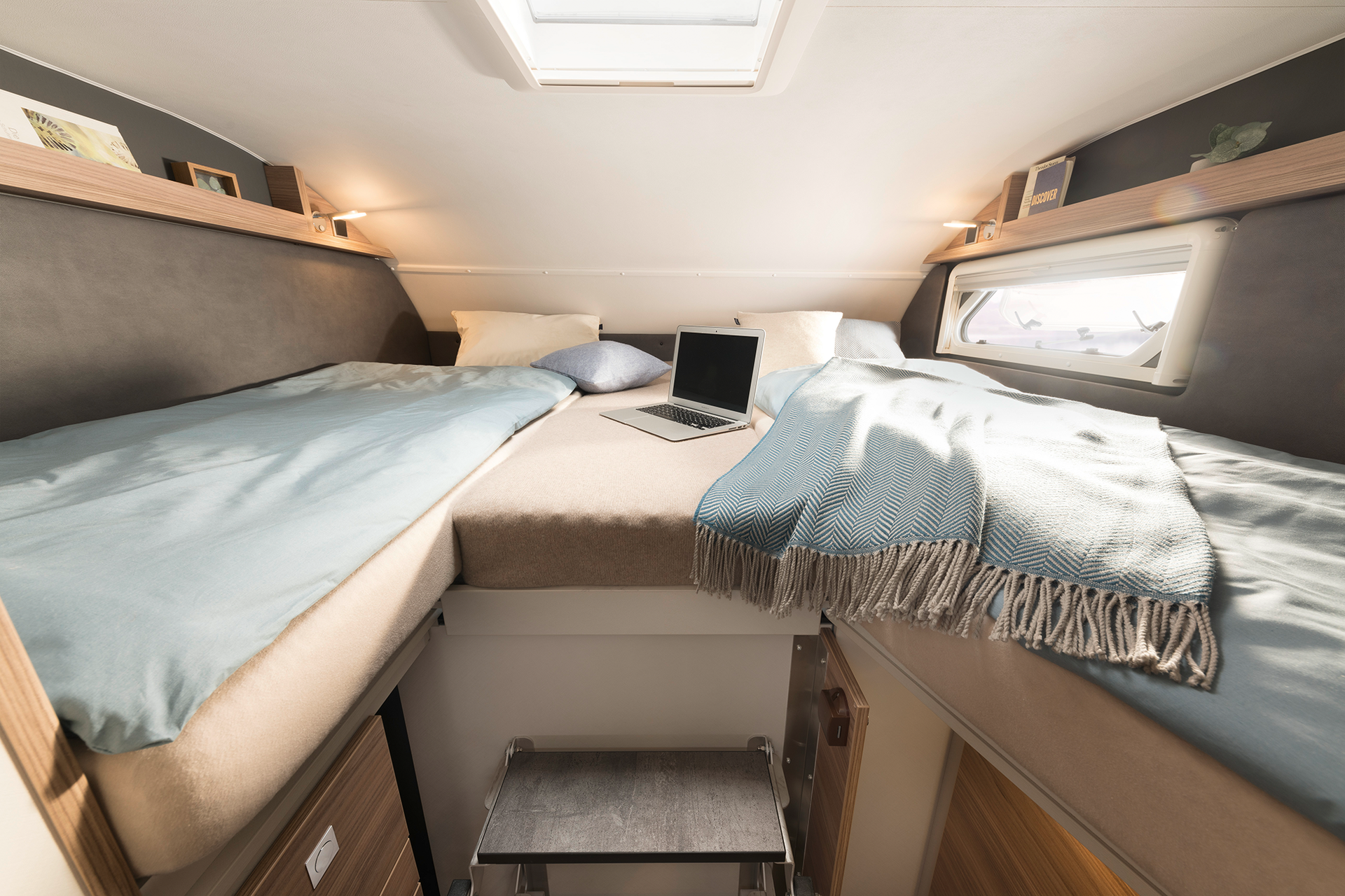 The overcab bed can be easily reached via the fold-away step. Practical: the wooden sliding door separates the living room from the driver’s cab • A 6820-2