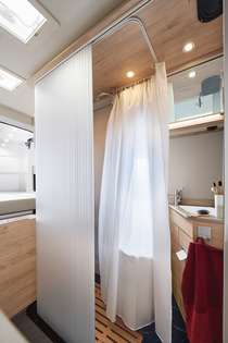 Komfortables Duschen auf einer sagenhaften Fläche von 87 x 47 cm. Multifunktionale Rollotüre: Sie trennt, auf Wunsch, Wohnraum und Bad voneinander ab. Wird sie eingerollt verwendet, entsteht ein offener Wohnraum der Superlative.