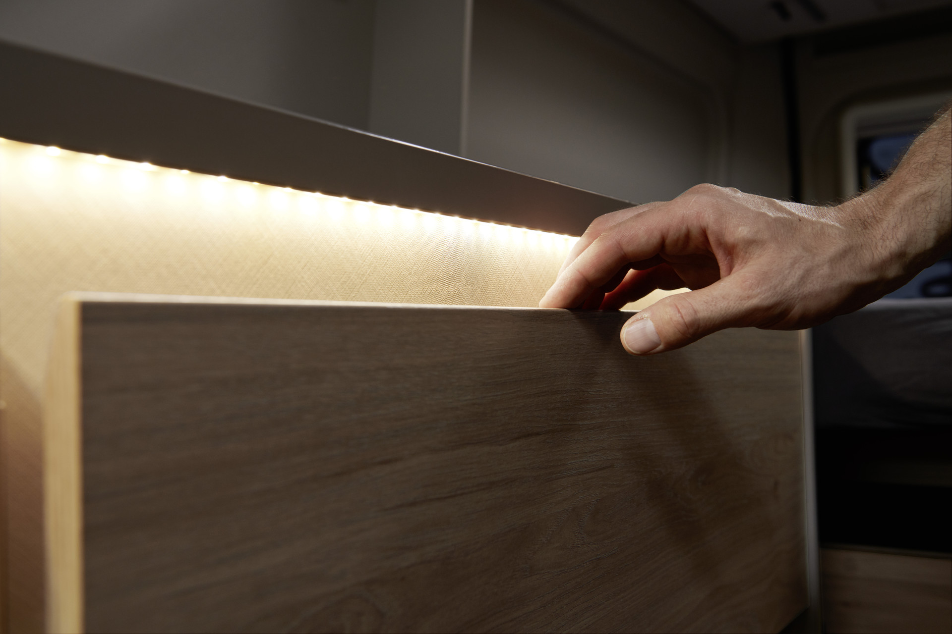 Ambient lighting inside the drawer illuminates the contents and creates a warm ambience