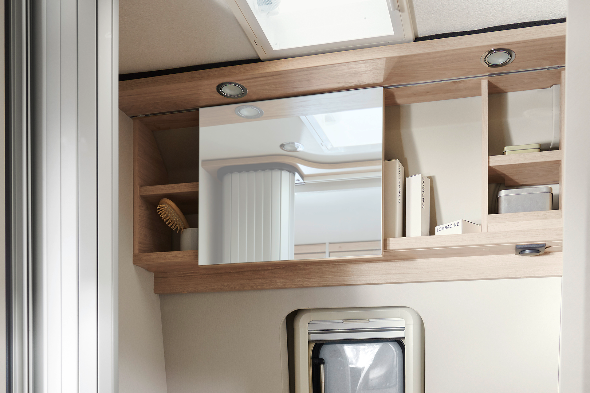 The bathroom features an overhead wall unit with plenty of storage space – individual items can be secured with smart rubber bands or by the sliding mirror door, which can be easily pushed to the side without restricting headroom.