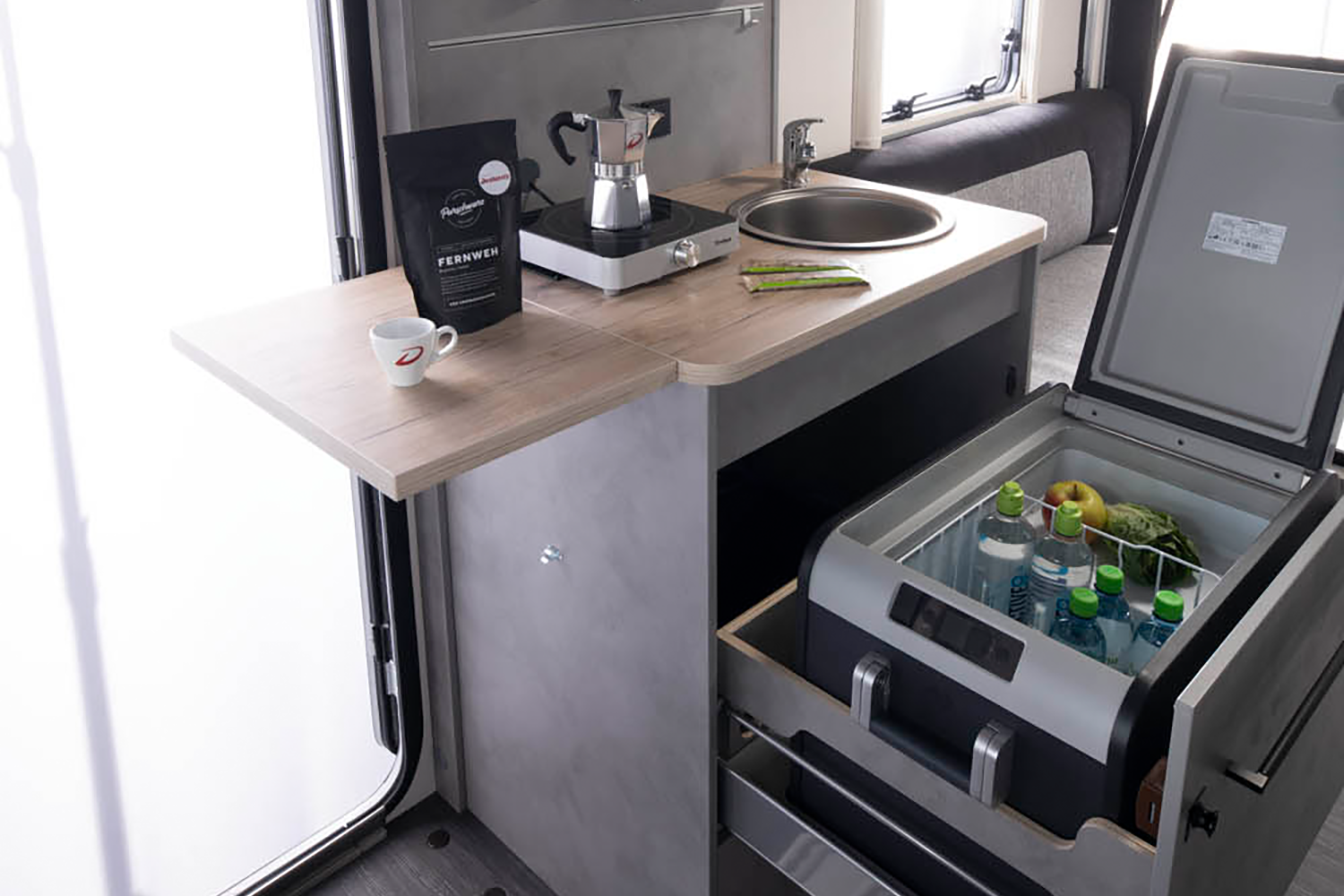 The compact kitchen unit with 10-litre fresh water and 10-litre waste water canisters, large kitchen worktop extension, induction hob and large drawer for the optional compressor cool box.